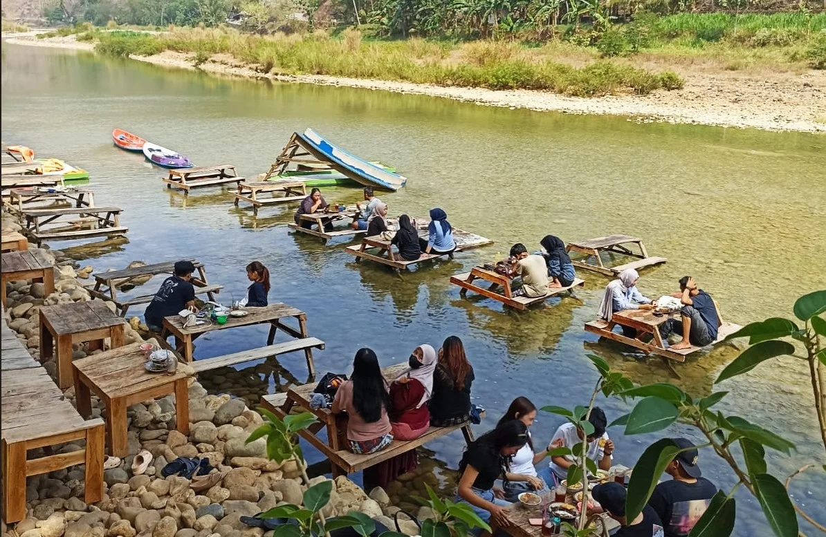 Warga menikmati soto "keceh" yang berada di aliran Sungai Oya Desa Wunut, Kapanewon Sriharjo, Bantul, DIY, Selasa (28/7/2026).
